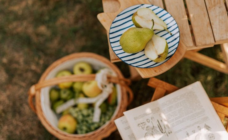 A picnic table with apples and vegetables on it